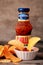 Studio shot of Hellmann`s chilly hot sauce and chips over vintage background. Hellmann`s brand nam