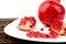 Studio shot open pomegranate on plate wooden mate