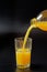 studio shot of orange juice and glass with bottle filling