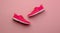 A studio shot of pair of running shoes on pink background. Flat lay.