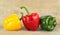 Studio shot of red,yellow,green bell peppers on woden plank