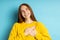 Studio shot of redhead caucasian young woman isolated blue background