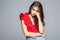 Studio shot of sad bored cute woman in t-shirt and jeans, leaning on fist and gazing up standing tired and upset over gray backgro