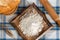 Studio shot of a scene from a room in a rural house. with a table with a retro checkered tablecloth, with flour, bread, muffins