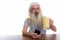 Studio shot of senior bearded man holding mobile phone and glass