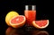 Studio shot sliced three grapefruits with juice isolated black