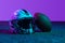 Studio shot of sportive professional equipment for american football game isolated over purple background in neon lights