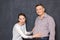 Studio shot of surprised woman touching big stomach of happy man