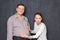 Studio shot of surprised woman touching big stomach of happy man