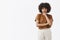 Studio shot of thoughtful suspicious and doubtful cute african american teenage girl with afro hairstyle in brown t