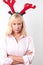 Studio Shot Of Unhappy Mature Woman Wearing Dressing Up Reindeer Antlers Against White Background