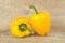 Studio shot of yellow bell peppers on wooden plank