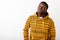 Studio shot of young black African man thinking while looking up