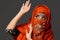 Studio shot of a young charming woman wearing the terracotta hijab decorated with sequins and jewelry. Arabic style.