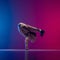 Studio shot of young flexible sportive man dancing breakdance in white outfit on gradient pink blue background. Concept