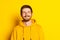 Studio shot of young happy man in yellow hoodie looking at camera isolated on bright background. Concept of human