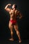 Studio shot of young male bodybuilder pose on black background,