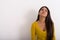 Studio shot of young stressed Indian woman thinking while lookin