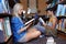 Studying wherever they find a quiet spot. Two students reading separate textbooks on the floor of the library.