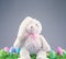 Stuffed animal Easter Bunny surrounded with painted Easter eggs and colorful decorations