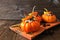 Stuffed autumn mini pumpkins with rice, cranberries, cabbage and nuts, side view on platter against rustic wood