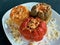 Stuffed bell peppers. Three cooked stuffed peppers on a white plate. Close-up. Juicy Peppers Recipe. Delicious multi-colored