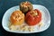 Stuffed bell peppers. Three cooked stuffed peppers on a white plate. Delicious multi-colored peppers stuffed with minced meat and