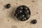 Stuffed black olives in a black plate on a stone background.