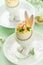 Stuffed or deviled eggs with yolk, shrimp, pea microgreens with paprika in rabbit-shaped stand for easter table decorate fresh