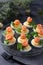 Stuffed eggs with salted salmon and cheese, a delicious festive snack on a dark background.