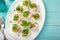 Stuffed eggs on whte plate for easter table, blue background