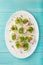 Stuffed eggs  on whte plate for Easter table, blue background