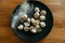 Stuffed homemade dumplings on a dark plate with flour on wooden table. Russian pelmeni