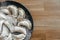 Stuffed homemade dumplings on a dark plate with flour on wooden table. Ukrainian vareniki