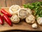 Stuffed mushrooms cups and chilly peppers and garlic cloves on a wooden board and table. High quality product with breadcrumbs,