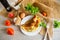 Stuffed omelette with tomatoes on a light wooden background.