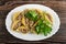 Stuffed pasta conchiglie, parsley in dish on wooden table. Top view