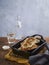 Stuffed roasted aubergine, brinjal or eggplant with a meat and veggie filling and savory bechamel on a wooden table with space for