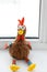 stuffed rooster sitting near the window. soft toy rooster