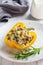 Stuffed sweet peppers with rice mushrooms and cheese with herbs. Baked halves of yellow peppers with filling. White