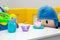Stuffed toy doll sitting on a chair with cups and toy teapot on a table