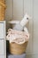 A stuffed toy is a homemade teddy bear on a basket with laundry in the decor of a children`s room in a Scandinavian or minimalist