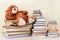 Stuffed toy Teddy bear lies among the stacks of books and dreams the concept of baby learning