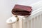 A stuffed wallet lying on a radiator, The concept of rising apartment heating costs