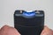 A stun gun in hand is a close-up. Electric discharge between the contacts of the device. Taser is on a white background