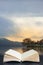 Stuning Autumn Fall sunrise landscape over Coniston Water with mist and wispy clouds coming out of pages in book composite image