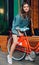 A stunner young girl in fashionable denim jacket posing on a background of a summer outdoor cafe on a warm evening