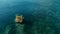 Stunning aerial drone image of a colorful seabed reef with a cliff rock standing out of water in calm weather flat seas and