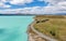 Stunning aerial high angle drone view of State Highway 8 leading along the shores of Lake Pukaki, an alpine lake