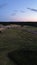 Stunning aerial landscape view of a sunlit, cloudless sky over an expansive rural farmland